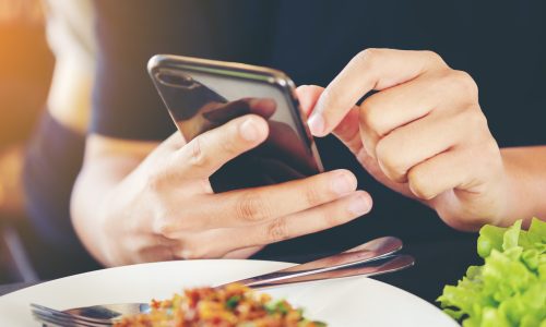 Close-up Man's hands use pointing finger Mobile smart Phone on Food table, technology and home concept